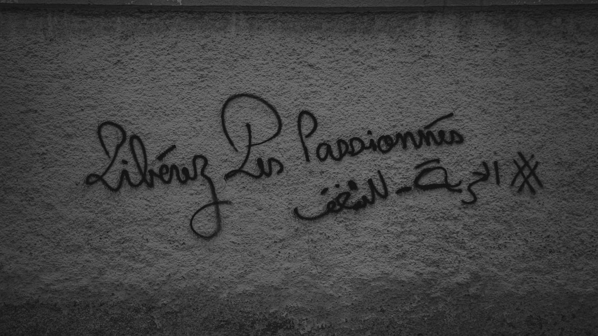 a black and white photo of graffiti on a wall